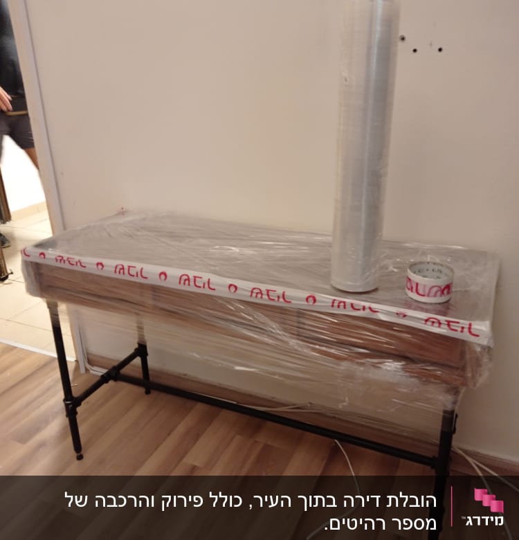 שולחן עטוף בניילון נצמד עם גליל וסרט דבק